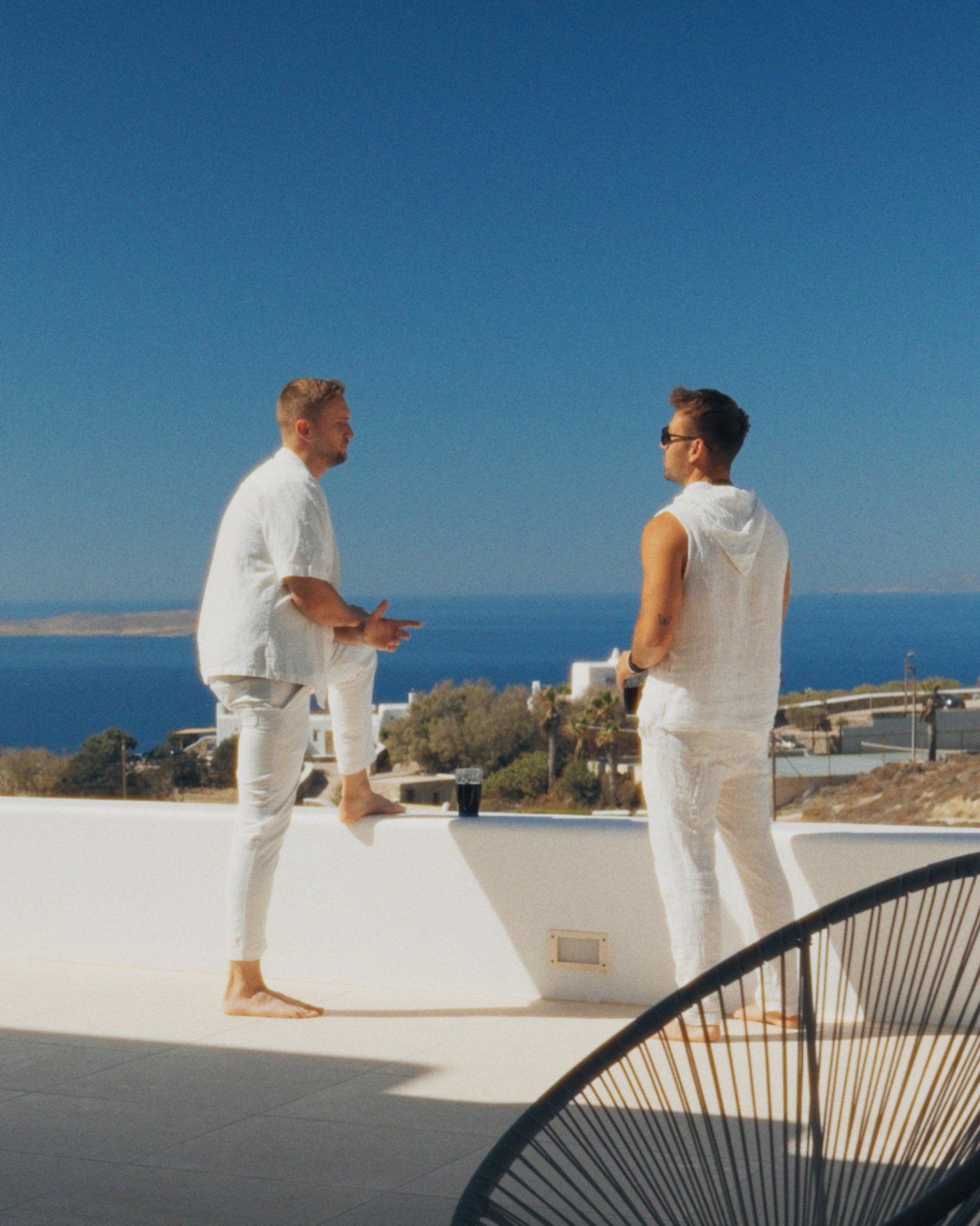 Two people talking together on a sunlit terrace